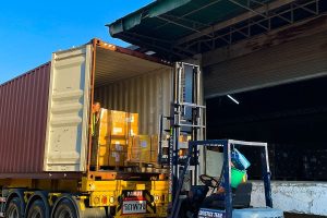Carga de un contenedor con carretilla en un almacén