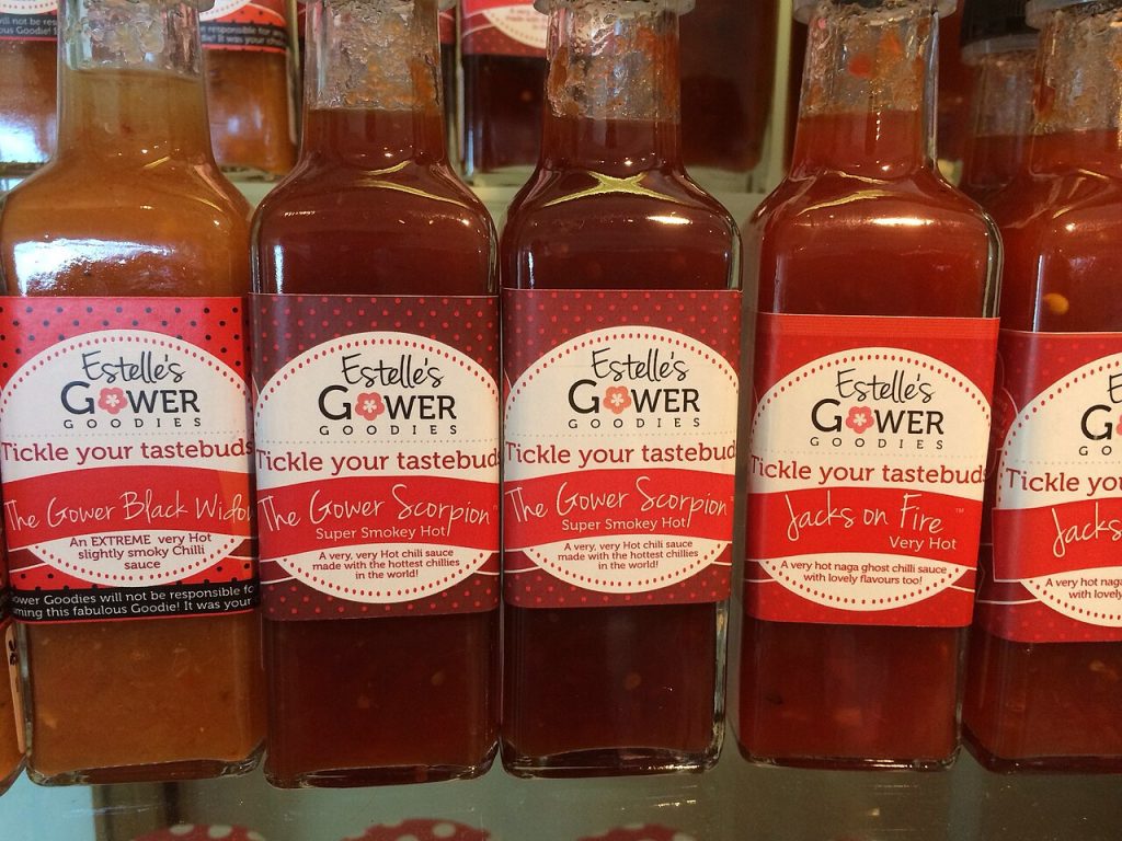 Botellas de salsa picante con etiqueta en un expositor
