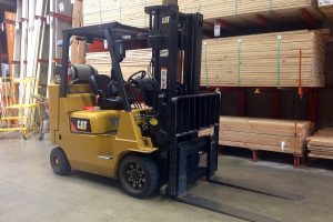 Carretilla elevadora Cat con palés de madera en un almacén ordenado