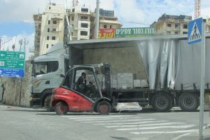 Carretilla elevadora Linde junto a un camión en una zona de carga del almacén