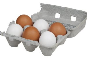 Huevos blancos y morenos en una caja de cartón