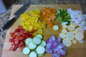 Verduras troceadas y cuchillo sobre una tabla de cortar